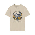 Priority Belly Slide penguin T-shirt in Sand: Inside a round frame, the penguin belly-slides along an airport luggage…