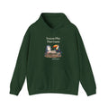 Toucan Play That Game penguin hoodie in Forest Green: The chinstrap penguin sits across from a toucan at a stone…