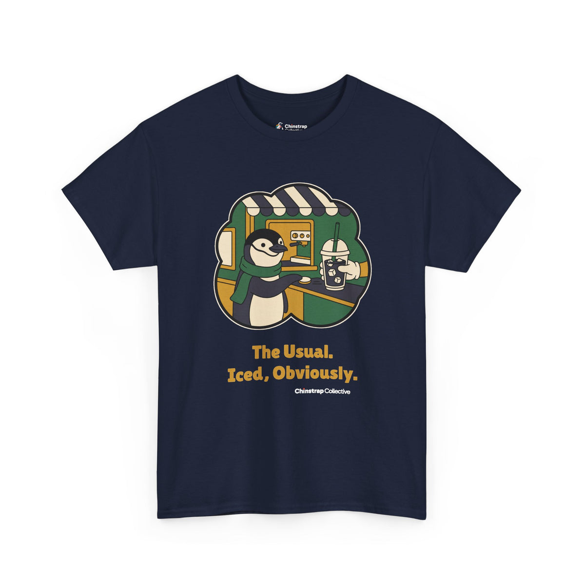 The Usual penguin T-shirt in Navy: Inside a green and gold sticker-style frame, the penguin in a green scarf slides a…
