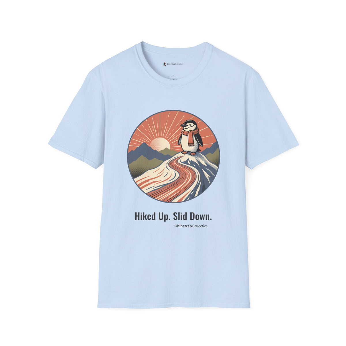Hiked Up penguin T-shirt in Light Blue: Under a rising sun with fanned rays, the penguin in an orange scarf stands