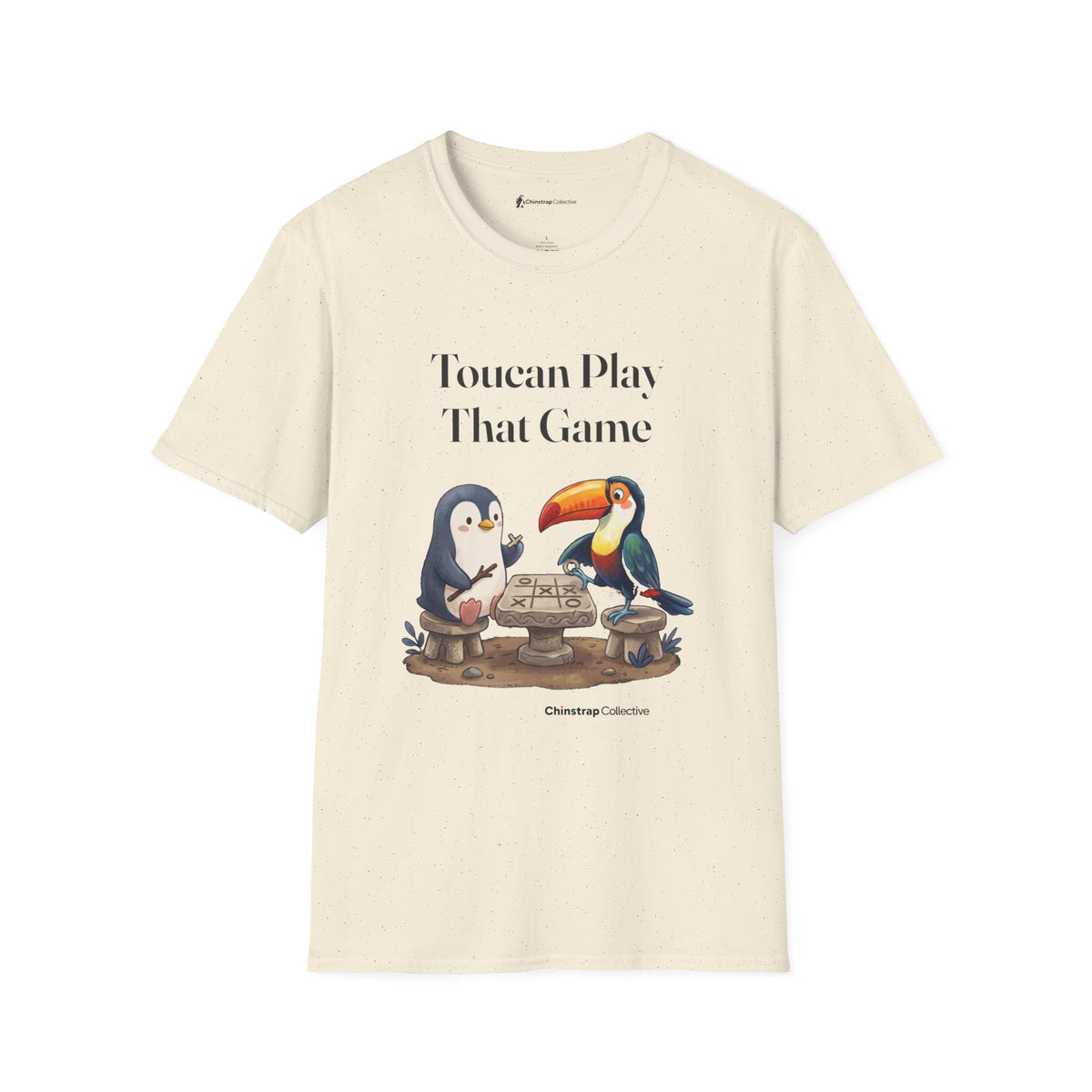 Toucan Play That Game penguin T-shirt in Natural: The penguin and a bright toucan sit on stone stools at a stone…